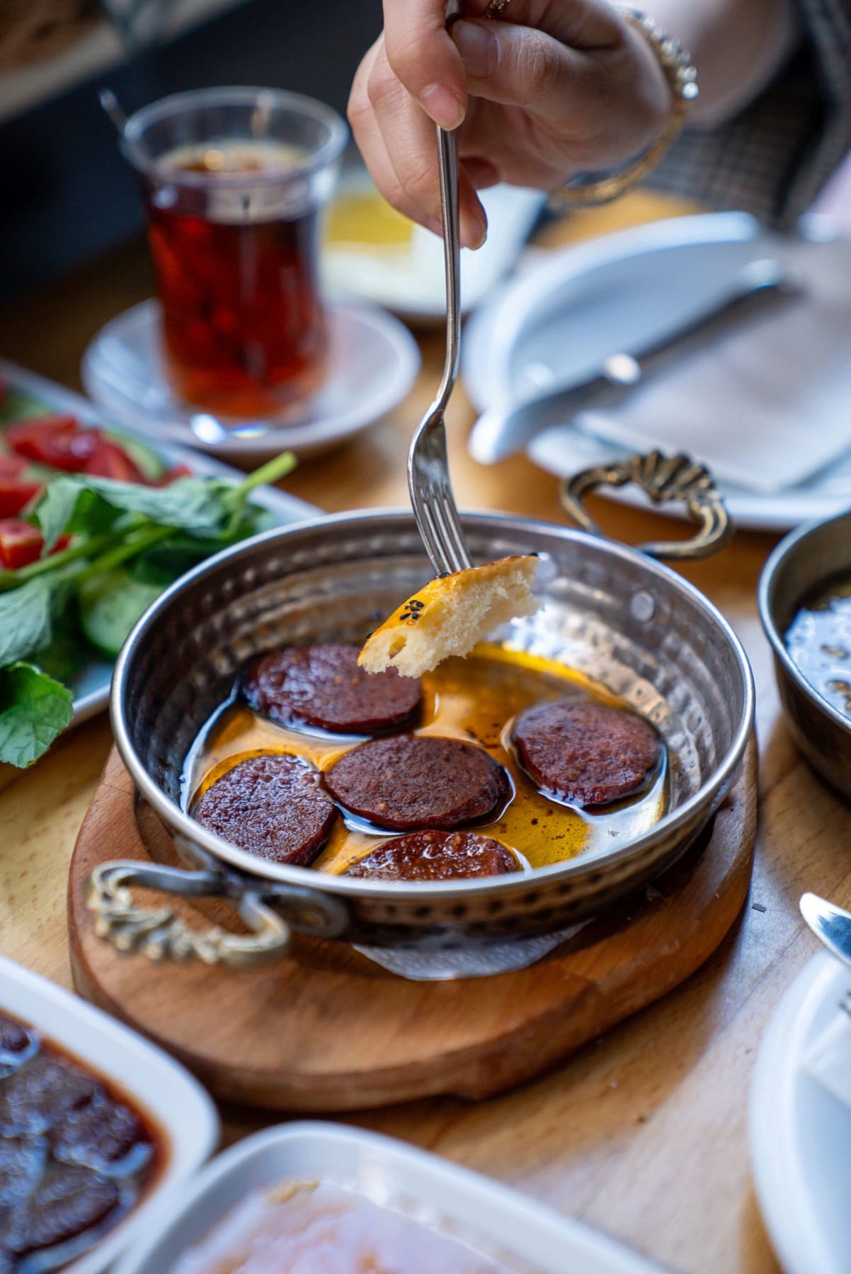 Eggs with sliced sucuk in a copper pan