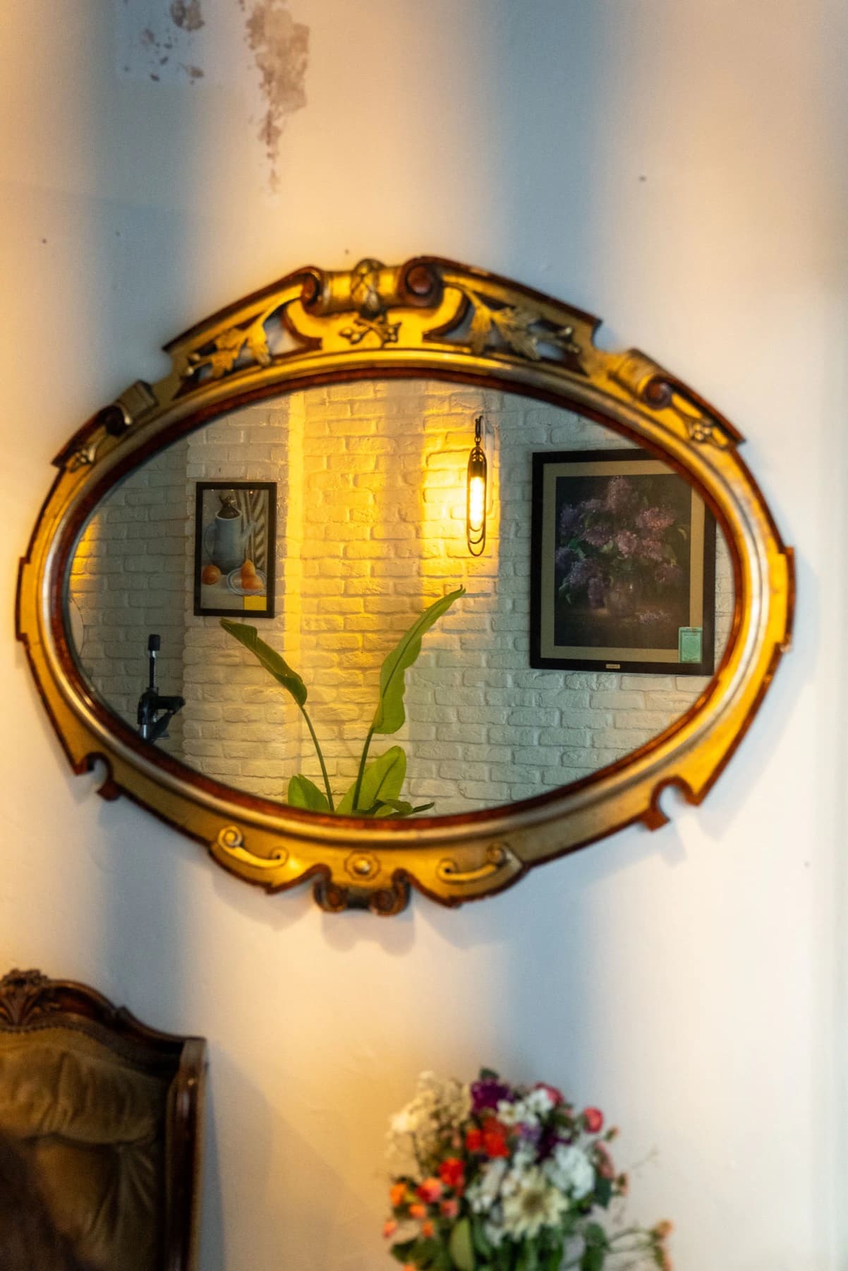 An ornate historic mirror reflecting the restaurant's brick wall
